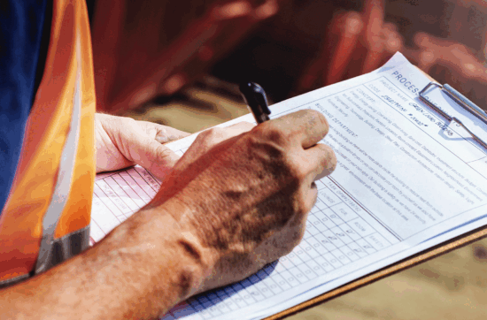Worker assessing quality control with a clipboard